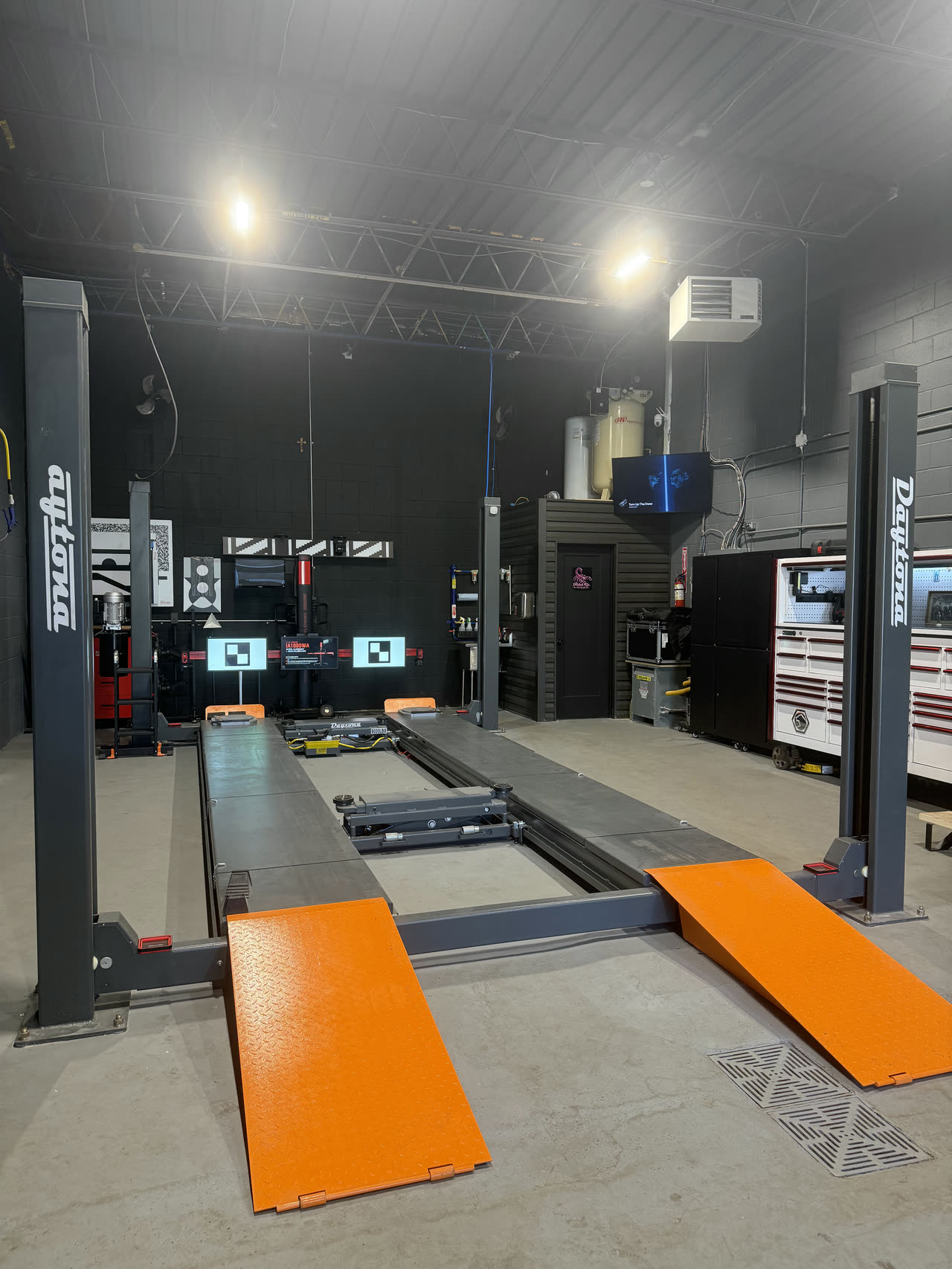 The Daytona four post alignment lift with its orange ramps down