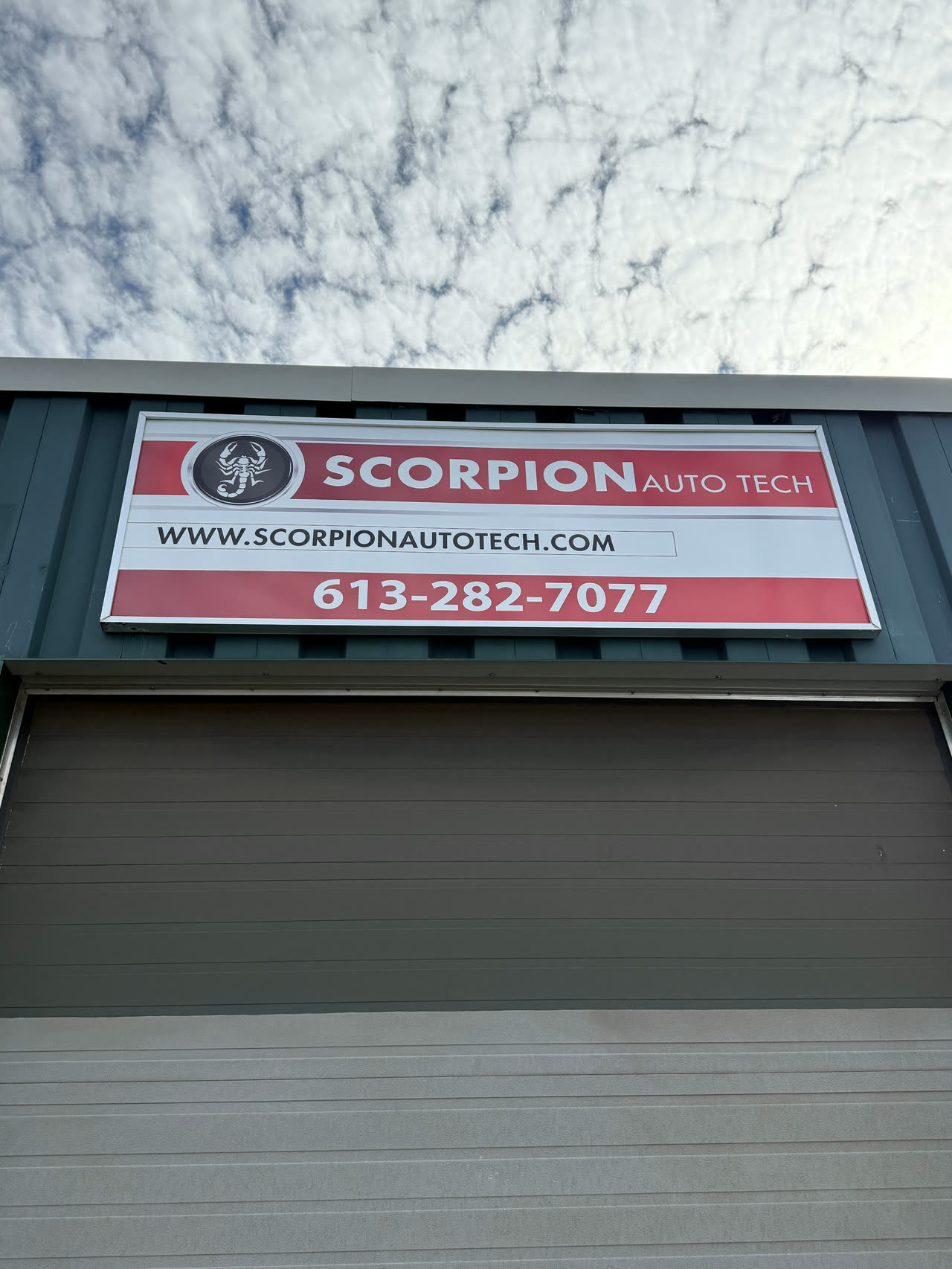 The red and white Scorpion Auto Tech sign above the bay door