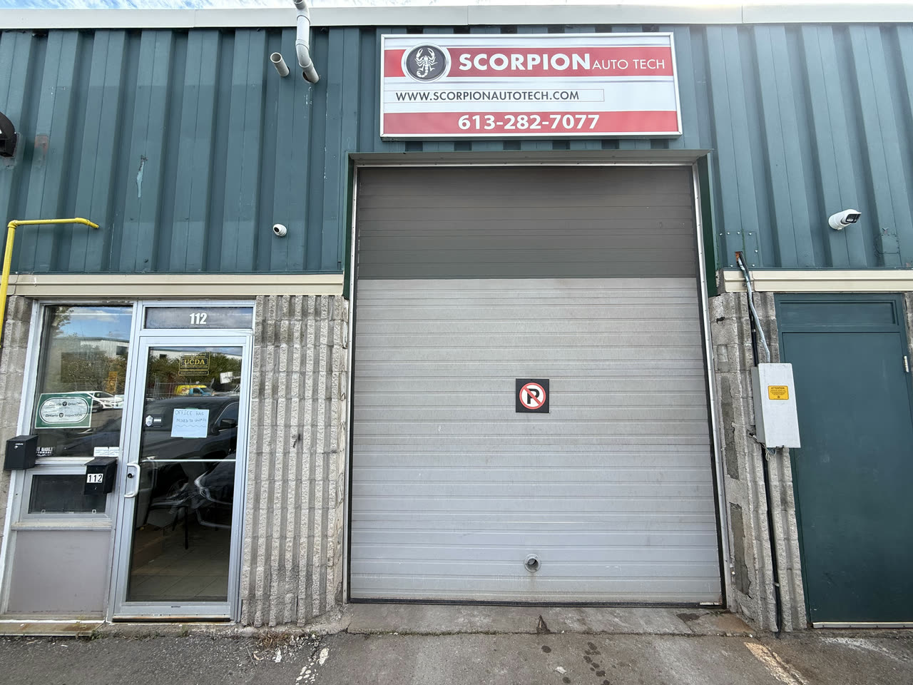 The customer entrance at Unit 112, the glass door left of the bay door